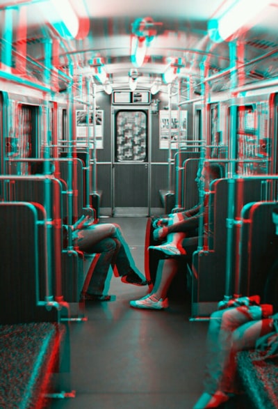 灰度的照片里面两人面对面而坐火车
